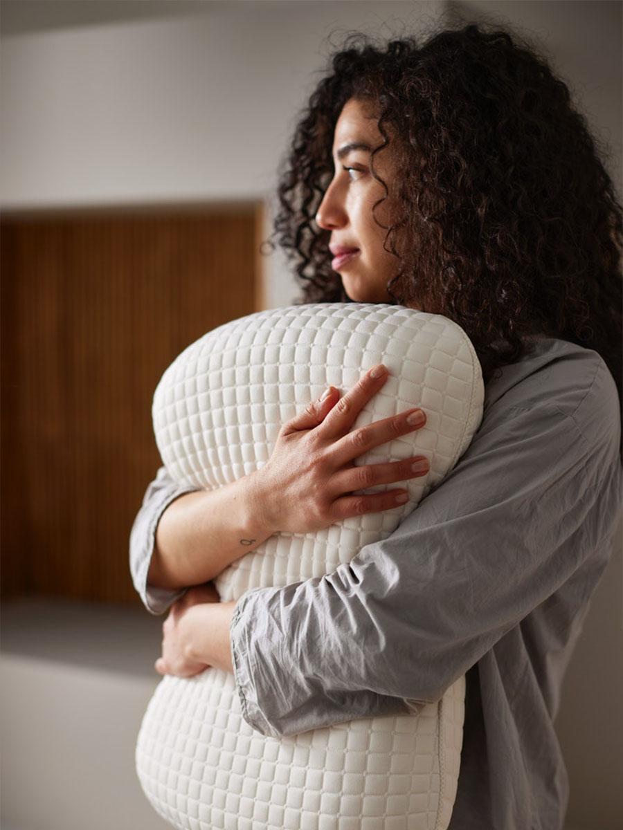 een vrouw houdt een hoofdkussen vast