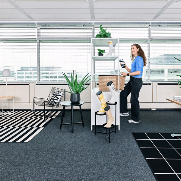 Een vrouw staat in haar kantoor ingericht met IKEA meubels door IKEA for Business