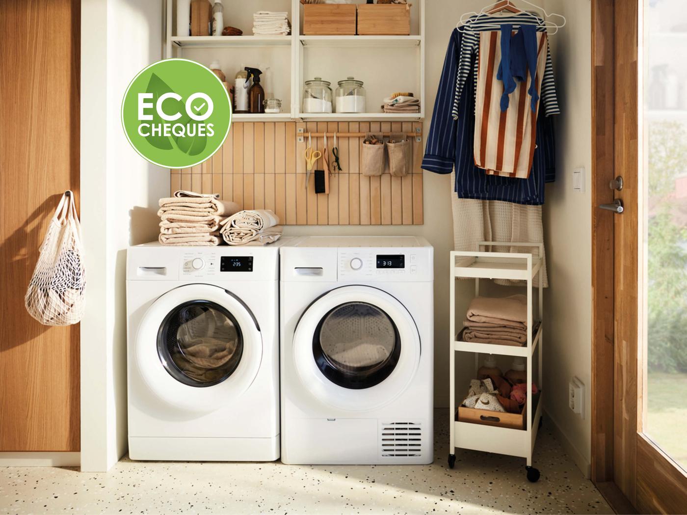 Een wasruimte met een wasmachine, droger, handdoeken op planken en hangende kleding.