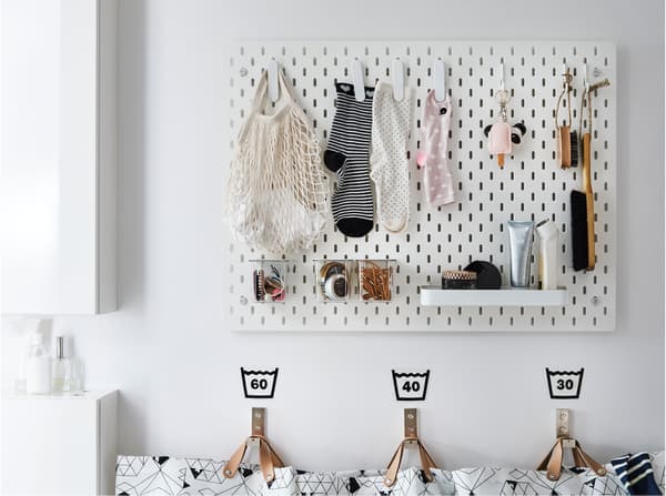 Een wit IKEA SKÅDIS ophangbord om losse sokken en andere huishoudelijke spulletjes in de wasruimte op te hangen.