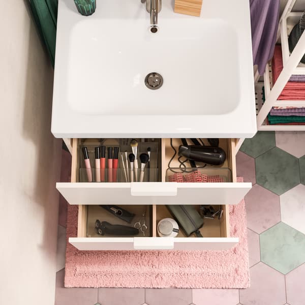 Een witte wastafel met twee open lades. De lades zijn ingericht met transparante doosjes in een rookkleur. De dozen helpen bij het organiseren van make-up en nog veel meer.