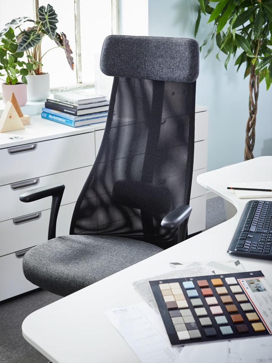 een zwarte bureaustoel met hoge rugleuning aan een bureau