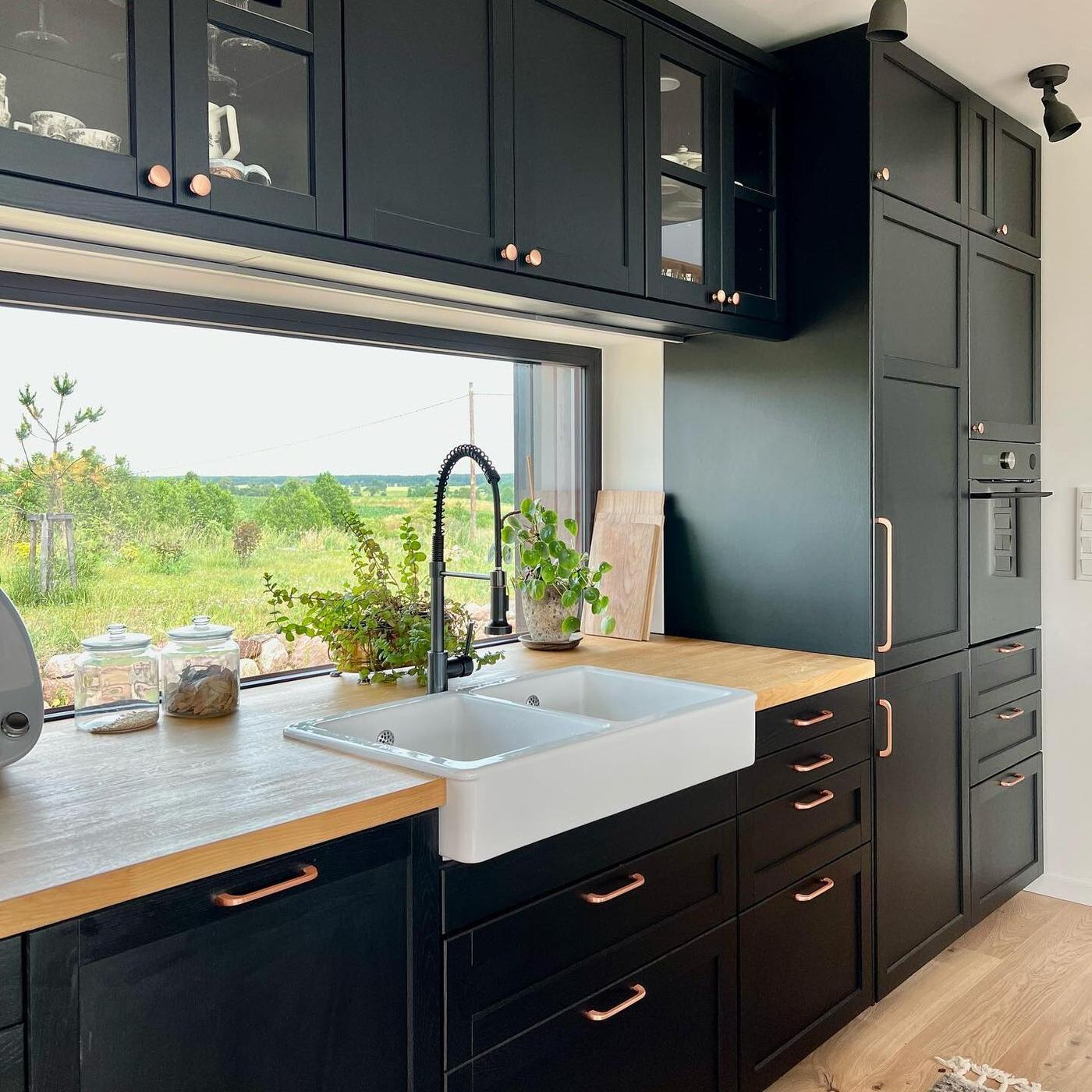 Een zwarte keuken met houten werkblad