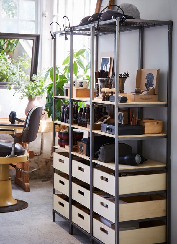 Egitura beltza eta zur naturalezko apalak dituen IKEA VEBERÖD apalategia. Goiko apalean bizargintzarako produktuak ikusi daitezke.