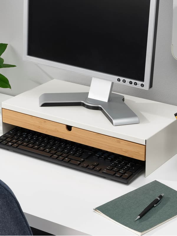 Egy fehér íróasztalon egy fiókos ELLOVEN monitorállvány áll.