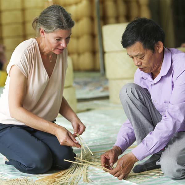 Egy férfi tradicionális bambuszfonó technikákat tanít Emma Olbersnek.