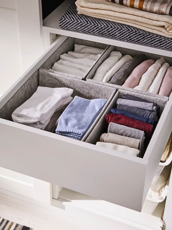 Egy fiókban szürke KOMPLEMENT dobozokat látunk, bennük szépen elrendezett zokni-kat.