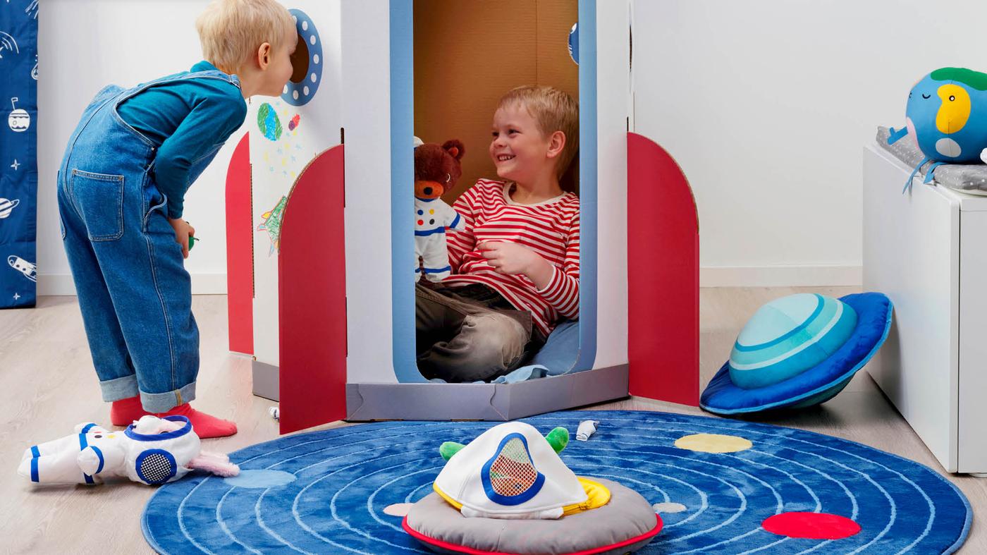 Egy fiú egy másik fiút néz, aki egy AFTONSPARV rakétában ül.