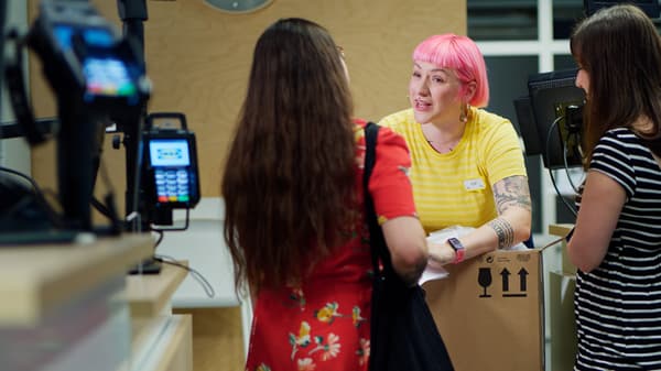 Egy IKEA-alkalmazott egy vásárlói kéréssel foglalkozik.