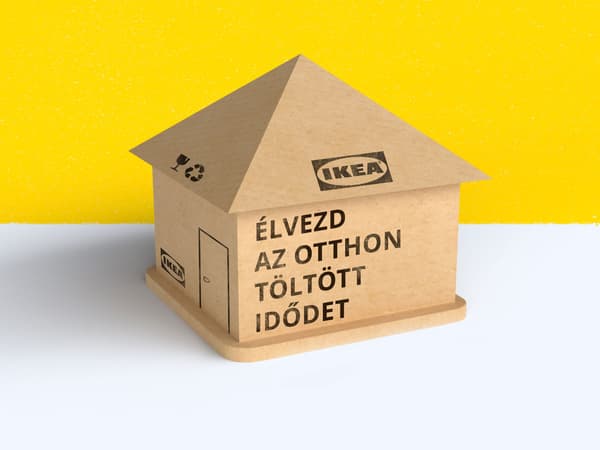 Egy IKEA dobozokból készült házikó, rajta felirat: Élvezd az otthon töltött idődet.