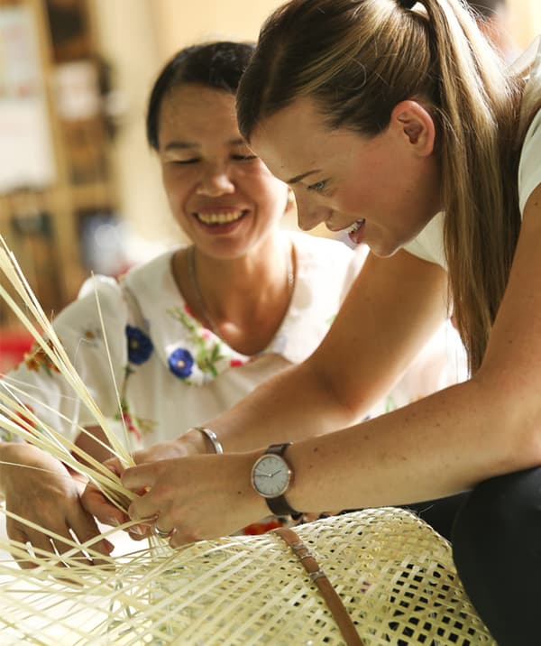 Egy nő a hagyományos bambuszfonó technikát tanítja Anna Granath számára.