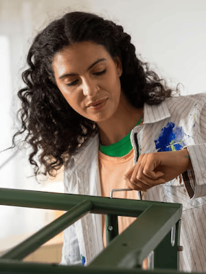 Egy nő zöld szekrényeket fest – felújítás IKEA termékekkel