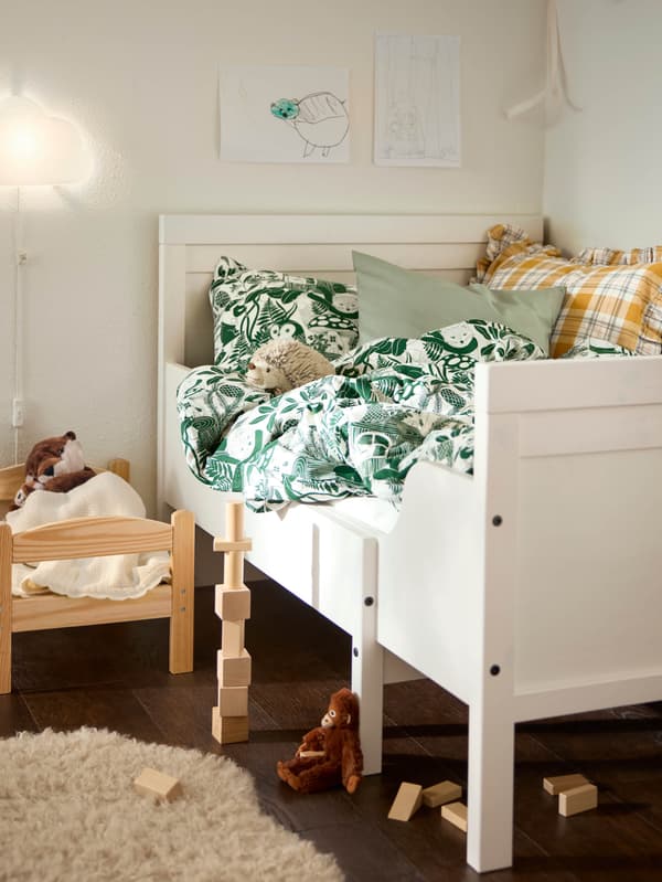 Egy SKOGSDUVA puha játék vidra egy DUKTIG játékágyban, egy SUNVIK meghosszabbítható ágy mellett.