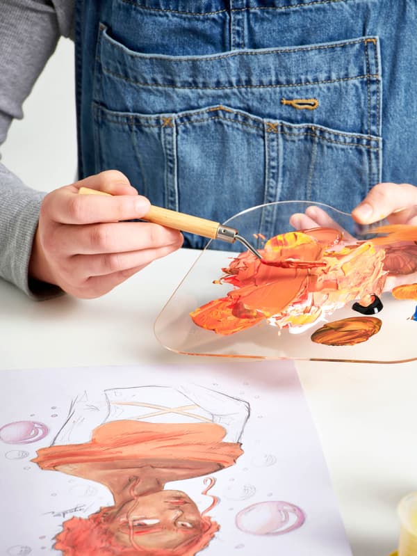 Egy SOLFÅGEL akrilfestékkel festő lány.