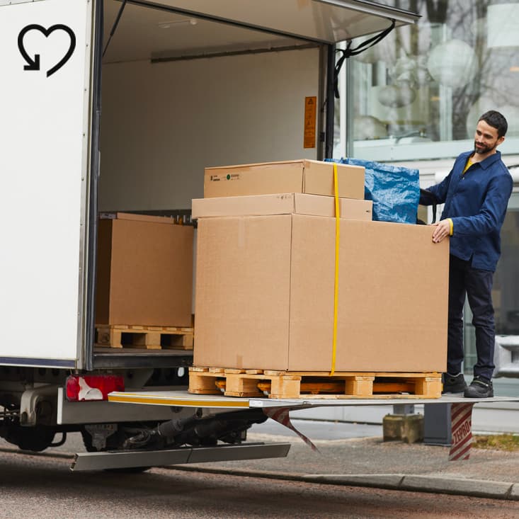 Egy személy csomagolt termékeket rakod ki egy teherautóból.