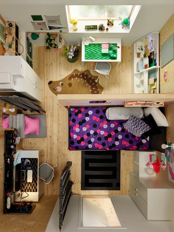 Egy térelválasztóval kettéosztott gyerekszoba egyik részben egy BRUMMIG sün alakú szőnyeg, a másikban egy fekete-szürke BLÅSKATA szőnyeg látható.