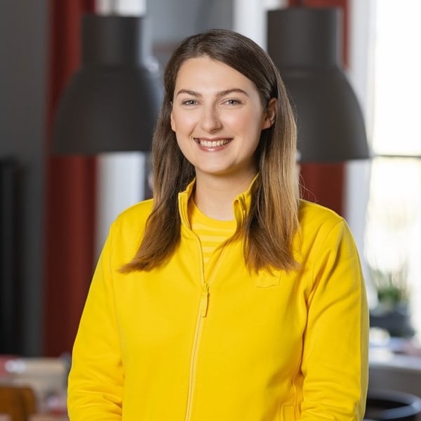 Эйманте Немане, руководитель отдела дизайна интерьера IKEA, улыбается в желтой униформе IKEA