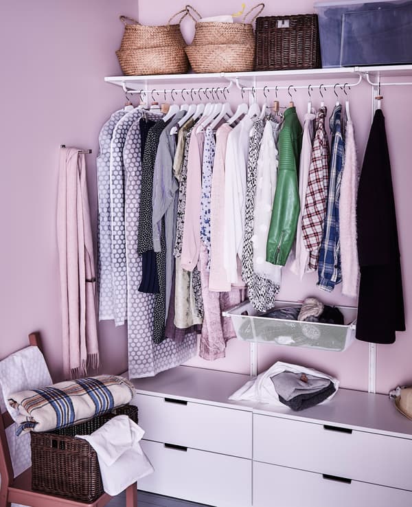 Ein begehbarer Kleiderschrank, hier u. a. eingerichtet mit ALGOT Wandschienen und Netzkörben in Weiss.