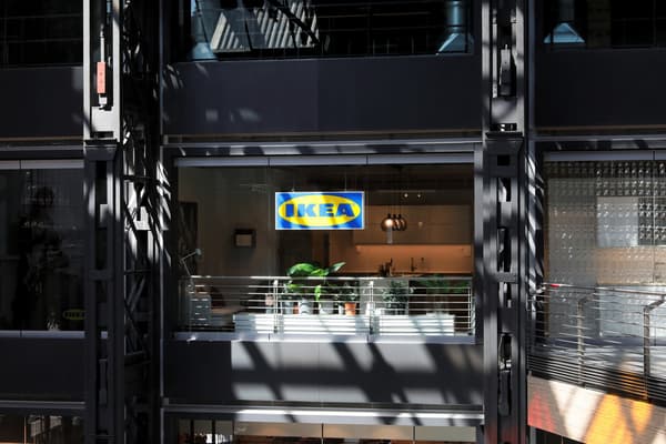 Ein blau-gelbes IKEA Schild vor einer Glasfront vor dem IKEA Planungsstudio.