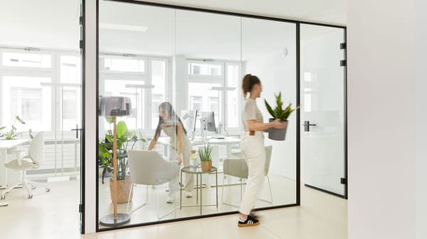 Ein Büroarbeitsplatz mit Schreibtisch, Büroshtuhl mit hoher Lehne und einem Büroregal mit Ablagemöglichkeiten für Dokumente