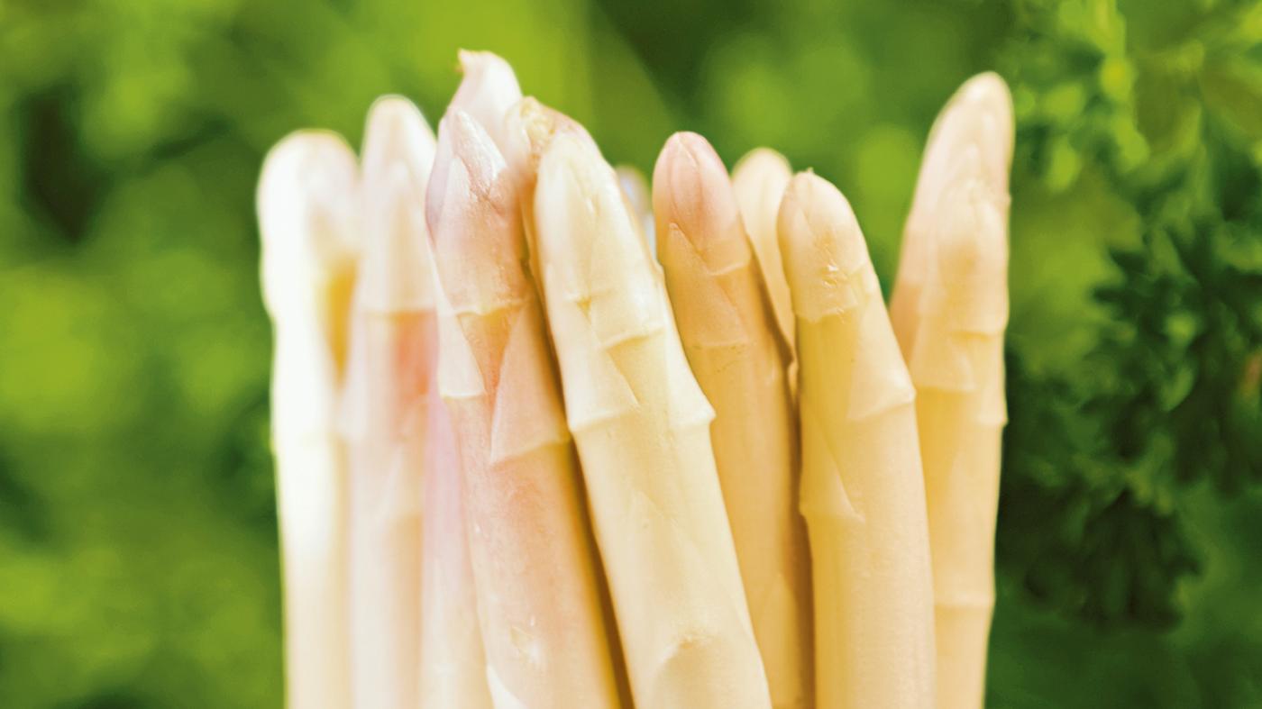 Ein Bund Spargel vor einem grünen Hintergrund.
