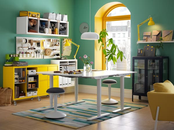 Ein buntes, farbenfrohes Büro in Grün, Weiß und Gelb mit zwei BEKANT Schreibtischen zum Sitzen & Stehen