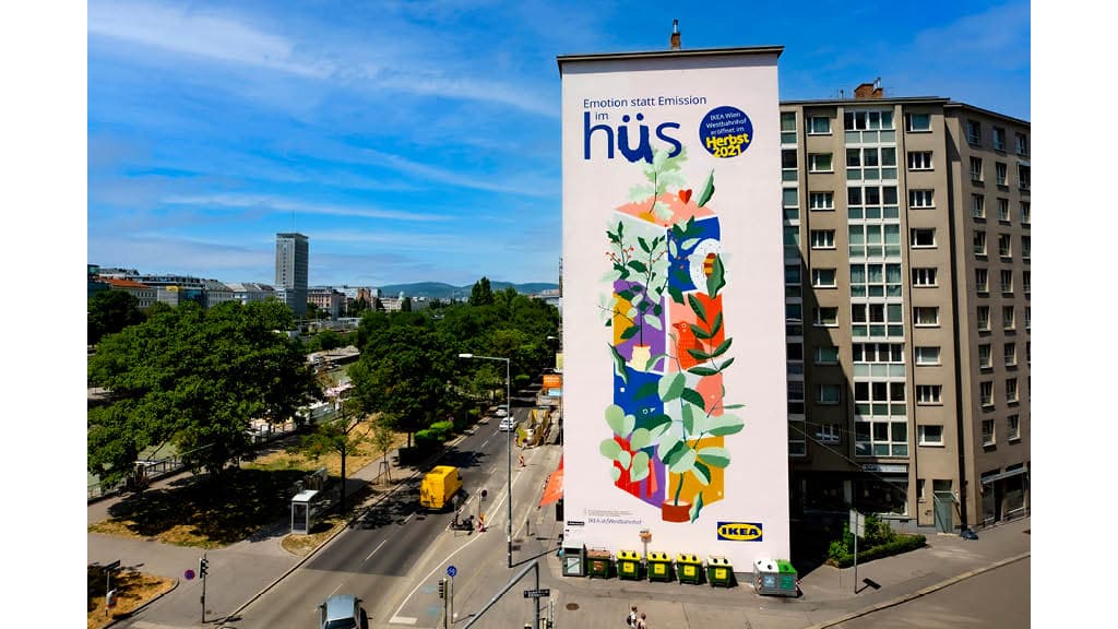 Ein Buntes großes Ikea Werbeplakat hängt über einem Wohnhaus