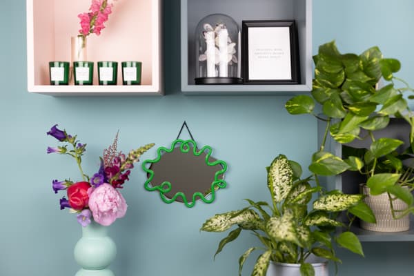 Ein DIY Wavy Mirror hängt an der Wand.