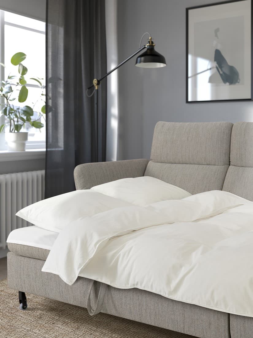 Ein FAMMARP Bettsofa ausgezogen. Darauf Bettzeug mit weißer Bettwäsche.
