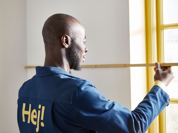 Ein Fenster wird mit einem Maßband ausgemessen.