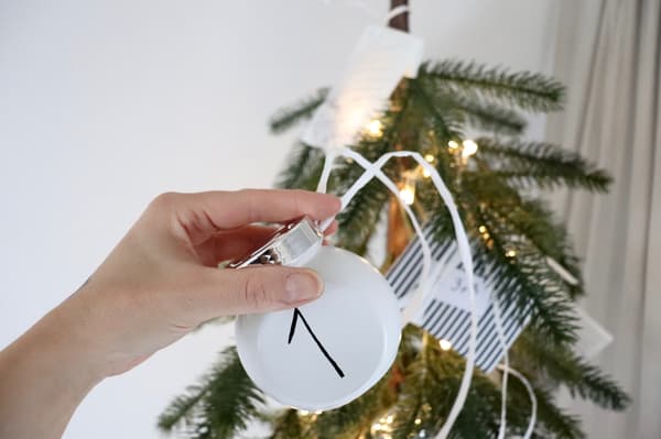 Ein Glas mit Bändern, um zu zeigen, wei man sie an den Adventskalender anbringt. 