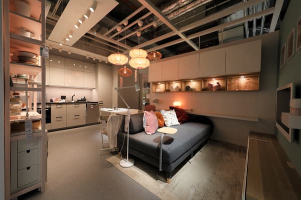 Ein graues Sofa mit bunten Kissen und vielen Lampen darüber.