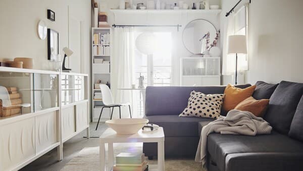 Ein grünes IKEA PÄRUP 2er Sofa mit waschbarem Bezug steht in einem Wohnzimmer, zusammen mit einem Esstisch, einem Stuhl und einem runden Couchtisch.