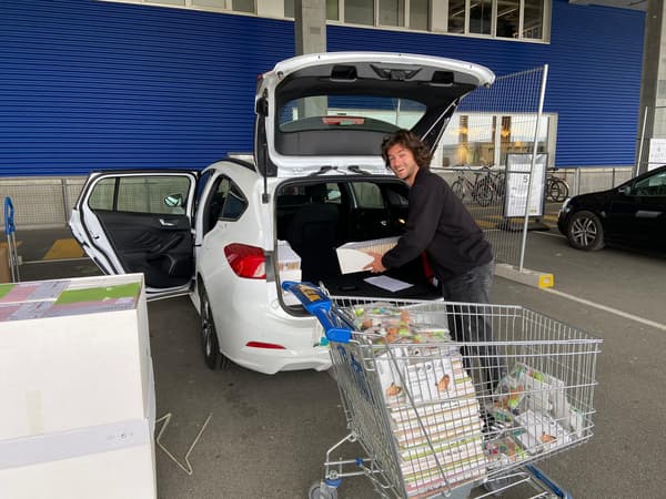 Ein IKEA Mitarbeiter belädt einen Kombi mit Spenden für Save the Children