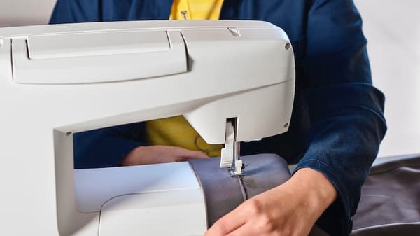 Ein IKEA Mitarbeiter, der eine Nähmaschine bedient