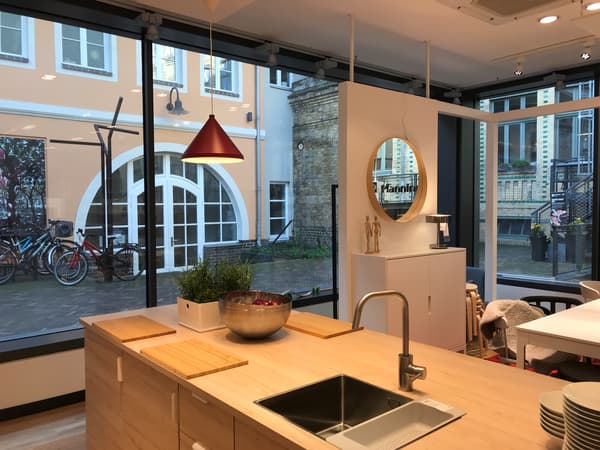Ein IKEA Planungsstudio von Innen, eine große Fensterfront im Hintergrund und im Vordergrund hängt eine Lampe über einer Küchentheke.