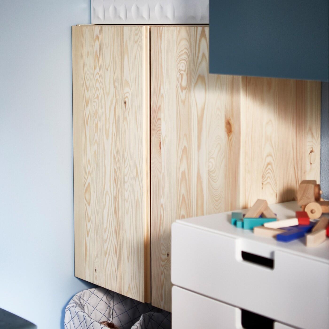 Ein IVAR Schrank als Aufbewahrung für Brettspiele und Unterhaltungsmedien mit Körben für Controller, Haken für Kopfhörer und Zeitschriftensammler als Aufbewahrung.