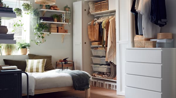 Ein kleines, aber dennoch gut organisiertes Schlafzimmer mit Holzbettgestell und einem Kleiderschranksystem.