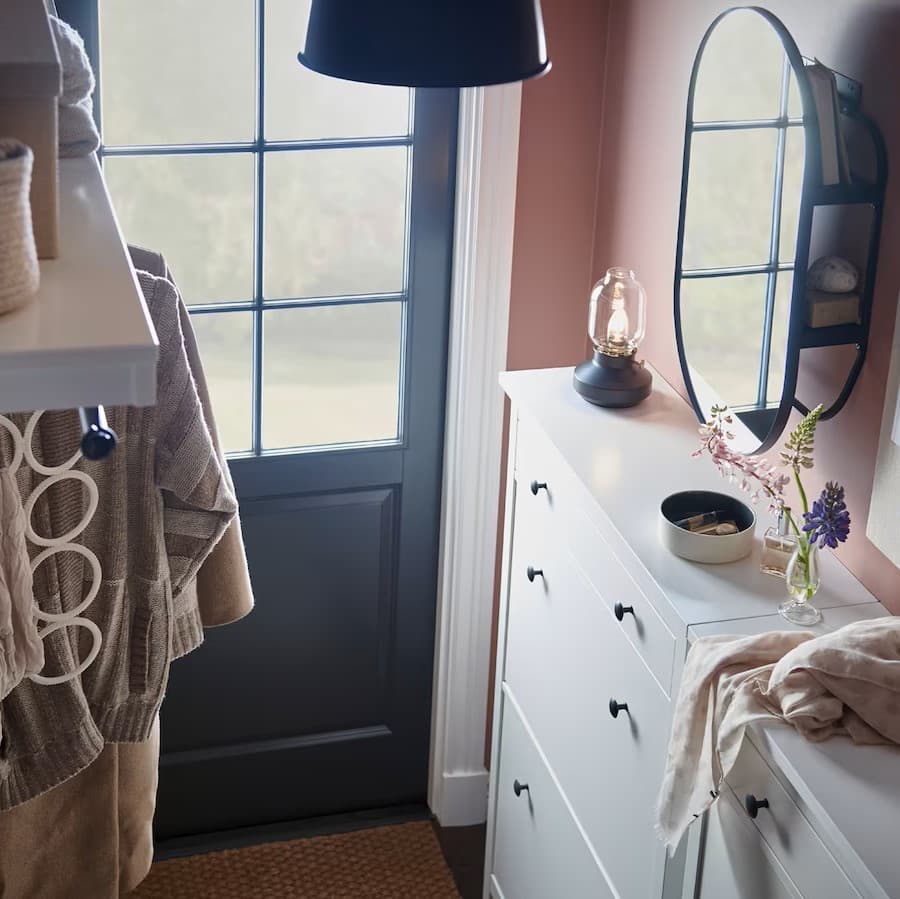 Ein kleines Vorzimmer aus der Vogelperspektive mit rosa Wandfarbe und weißem Schuhkipper.