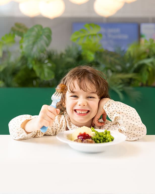 Ein Mädchen sitzt vor einem Teller KÖTTBULLAR im IKEA Restaurant