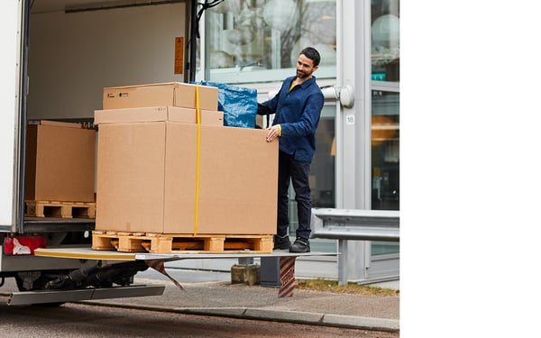 Ein Mann bringt Pakete aus dem Lieferwagen heraus.