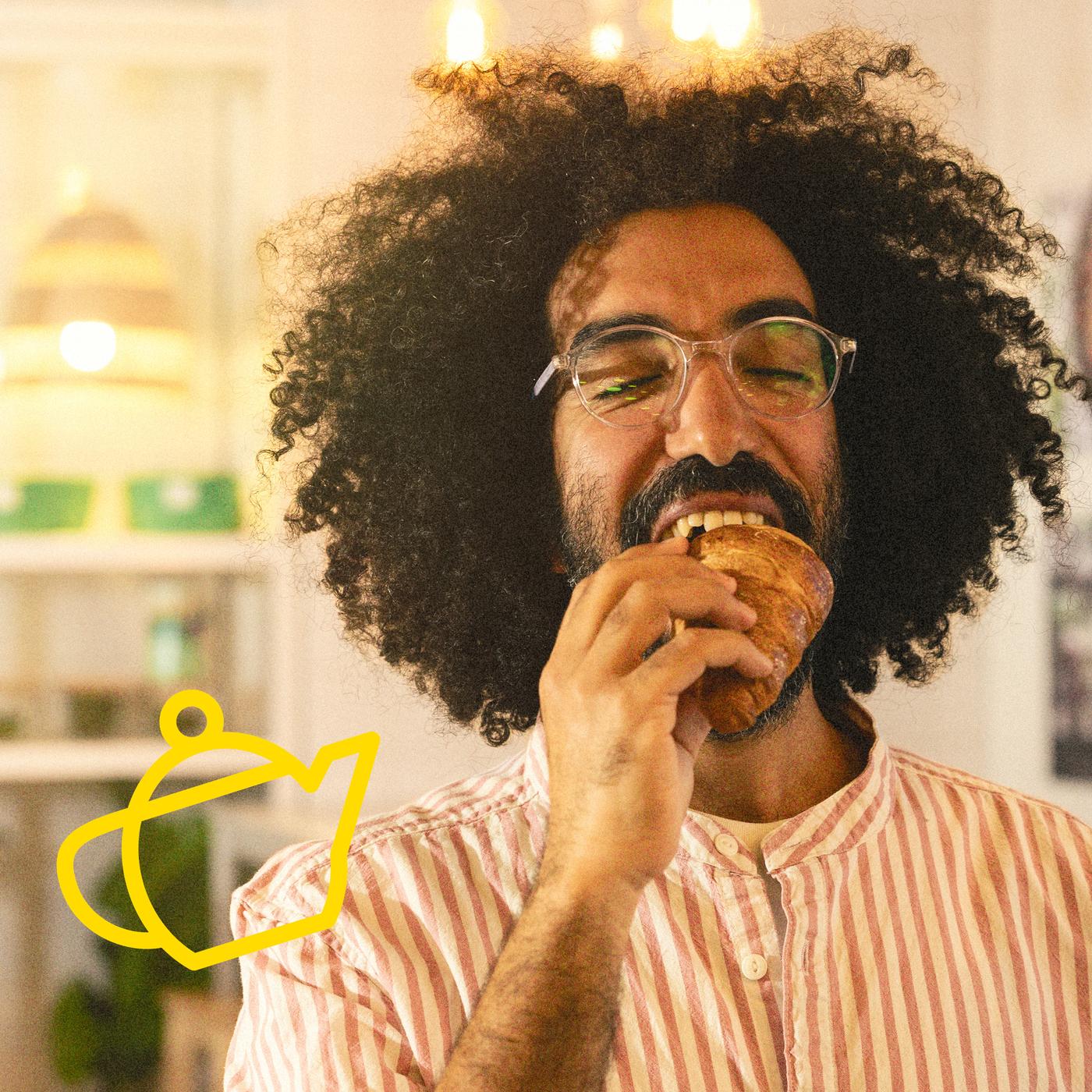 Ein Mann ist ein Croissant und freut sich