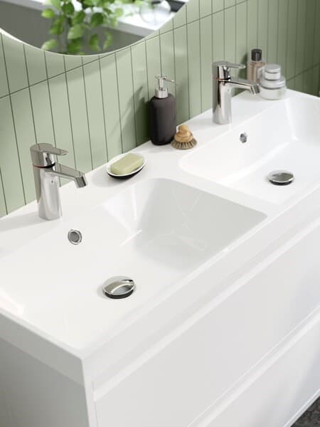 Ein ORRSJÖN Doppelwaschbecken vor einen grünen Fließenwand.