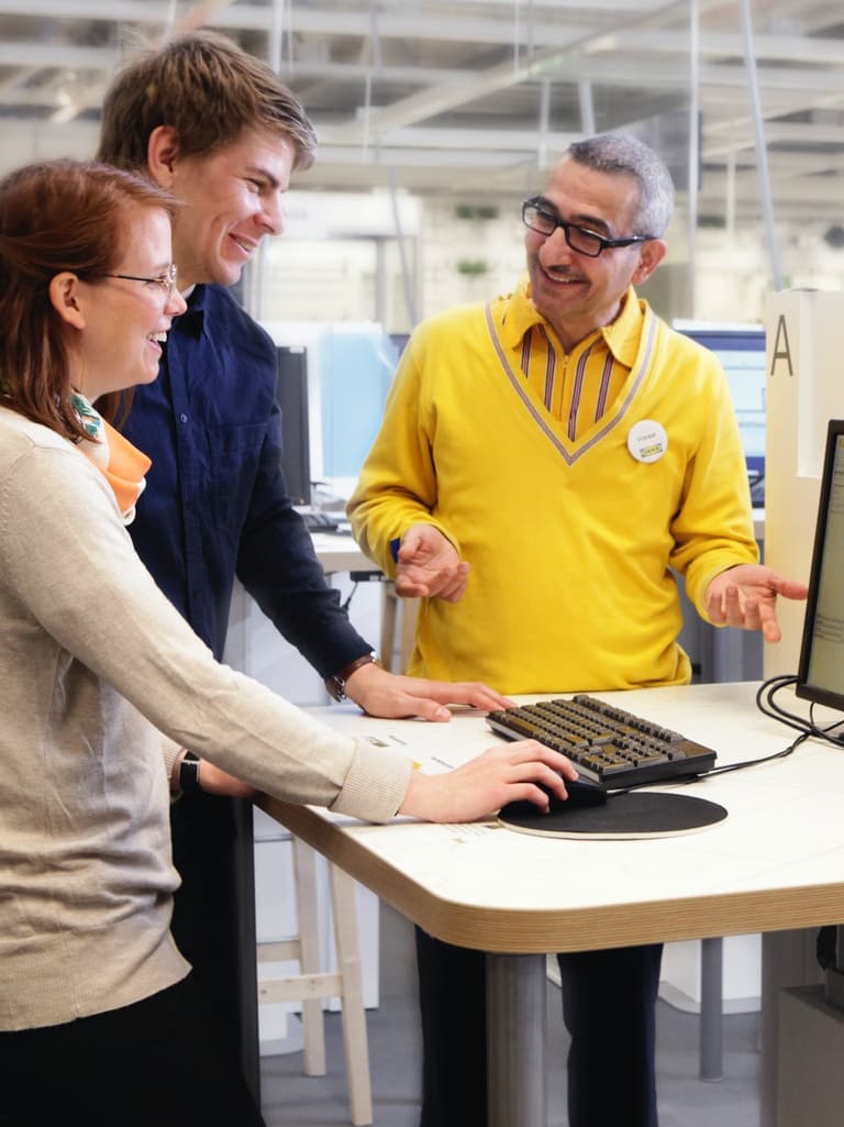 Ein Paar lässt sich von einem Planer bezüglich ihrer neuen Küche beraten. 