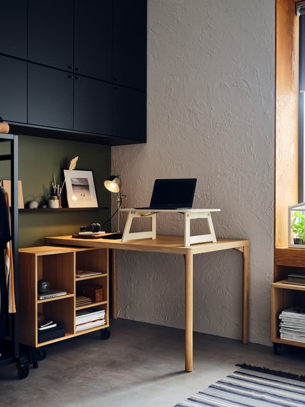 Ein RÅVAROR Esstisch und ein RÅVAROR Regal mit Rollen sind zu einem Schreibtischbereich zusammengestellt. Auf dem Tisch liegt ein Laptop.
