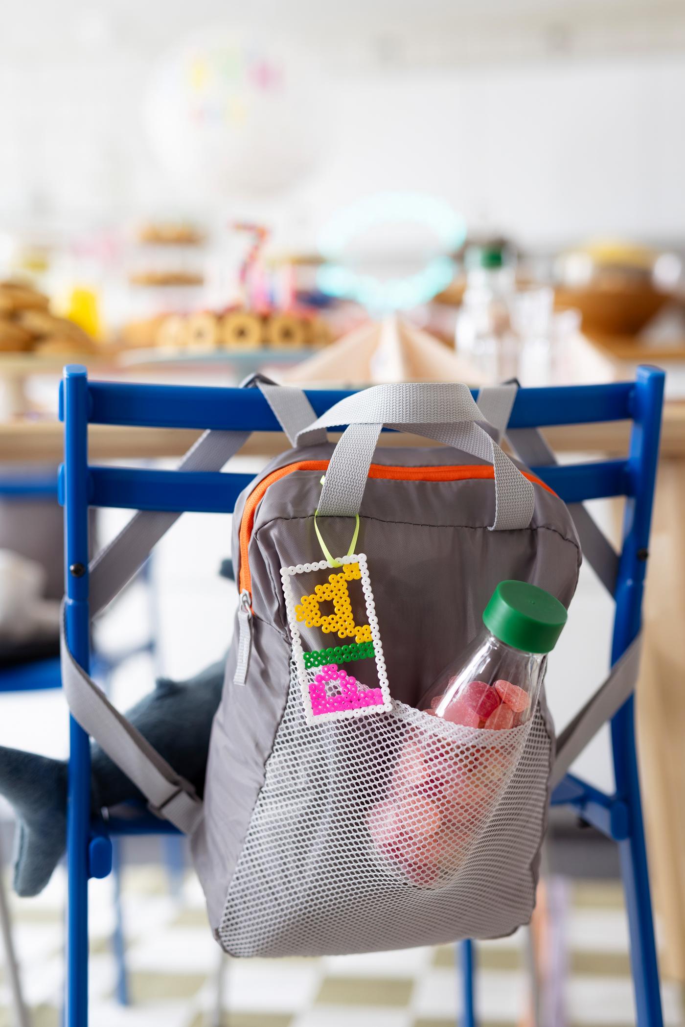 Ein Rucksack als Gastgeschenk hängt an einem Stuhl. 