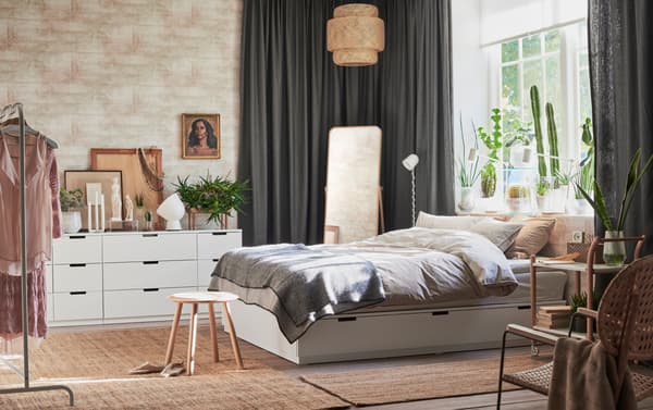 Ein Schlafzimmer mit NORDLI Bettgestell mit Schubladen in Weiß