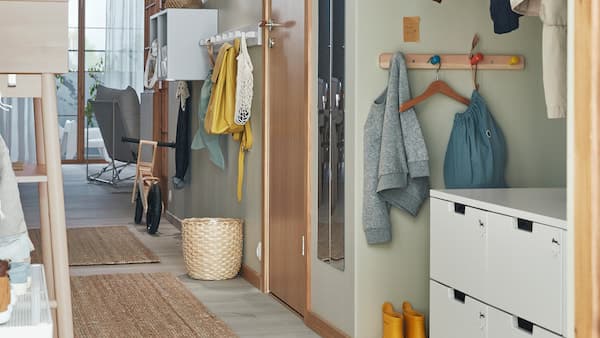 Ein schmale Diele mit smarter Aufbewahrung, u. a. mit einer NORDLI Kommode mit 6 Schubladen, Hakenleisten und mehr für Groß und Klein.