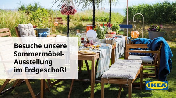 Ein schön gedeckter, frühlingshafter Tisch mitten im Grünen, umgeben von hohem Gras 
