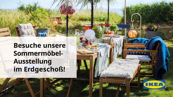 Ein schön gedeckter, frühlingshafter Tisch mitten im Grünen, umgeben von hohem Gras 